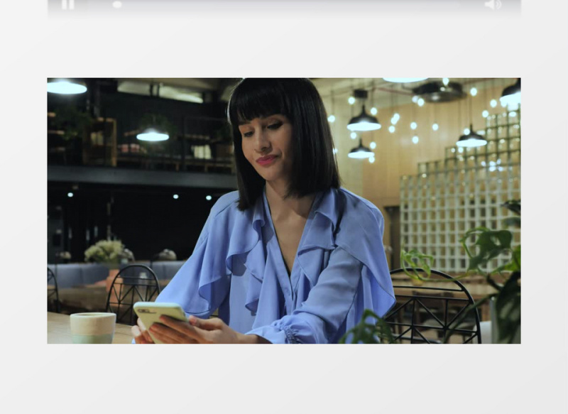 坐在餐吧玩手机的黑发女人实拍视频素材