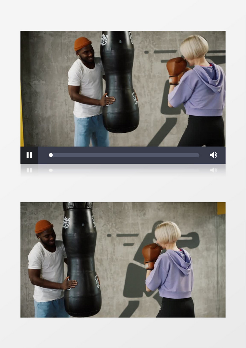 男子扶着沙袋看女子在练拳击实拍视频